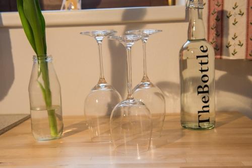 four wine glasses and a bottle on a table at Fridas in Kleinarl