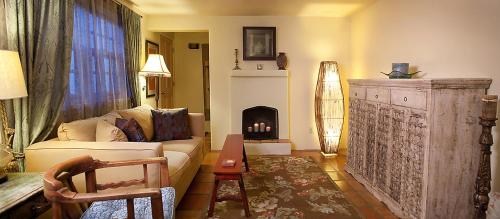 a living room with a couch and a fireplace at Casa de Tres Lunas/House of Three Moons in Santa Fe