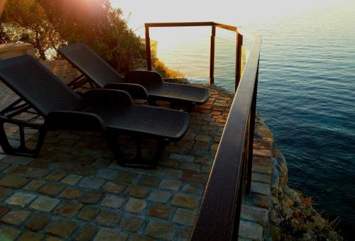 a group of chairs sitting next to the water at Vrachokipos in Souvala