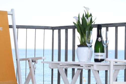 a table with a bottle of wine and a plant on a balcony at Residence Sabrina in Ceriale