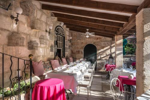 a restaurant with pink tables and chairs on a patio at Hotel Rural Biniarroca - Adults Only in Sant Lluis