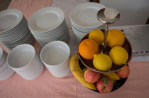 Een fruitschaal op een tafel met stapels borden. bij Mobile homes Bonaca in Srima