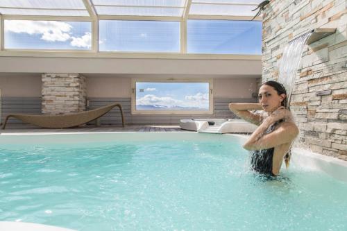 a woman is standing in a swimming pool at Hotel Donatello Imola in Imola