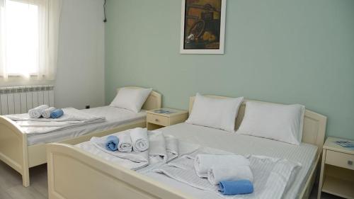 two beds in a room with towels on them at Hotel MK, Plavi restoran, Loznica in Loznica