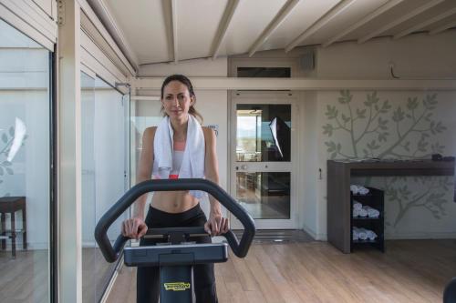a woman on an exercise bike in a room at Hotel Donatello Imola in Imola