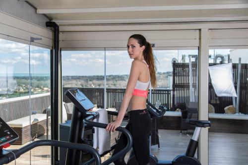 a woman walking on a treadmill in a gym at Hotel Donatello Imola in Imola