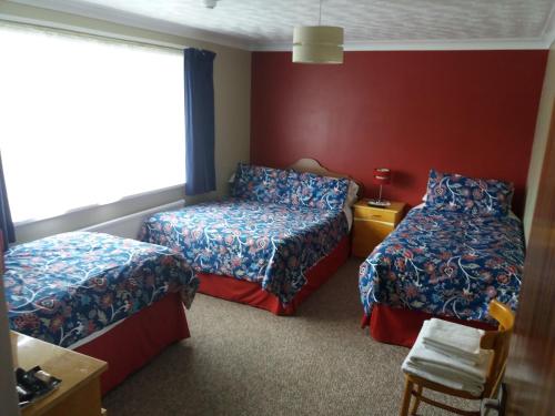 a hotel room with two beds and a window at Lynn Hill Guest House in East Dereham