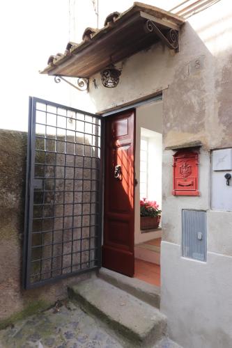 an entrance to a house with a red door at Platea Oche in Sutri