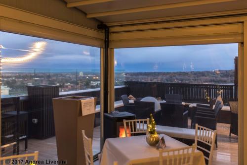 a restaurant with a view of the city from a balcony at Hotel Donatello Imola in Imola
