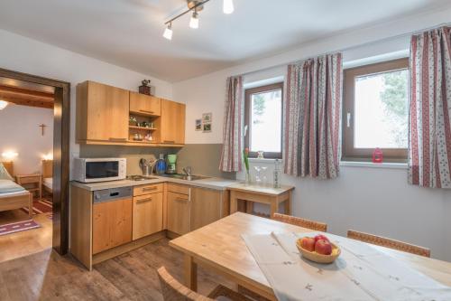 a kitchen with wooden cabinets and a table with a bowl of fruit at Fridas in Kleinarl