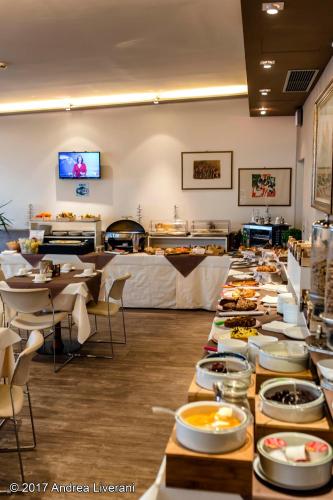 a buffet line with tables and plates of food at Hotel Donatello Imola in Imola