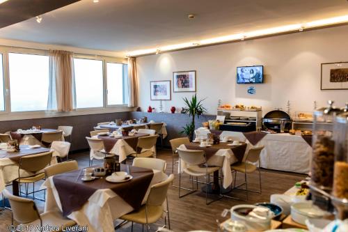 a restaurant with tables and chairs in a room at Hotel Donatello Imola in Imola