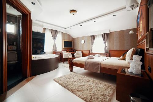 ein Hotelzimmer mit einem Bett und einer Badewanne in der Unterkunft Lux apartmani Beograd in Belgrad