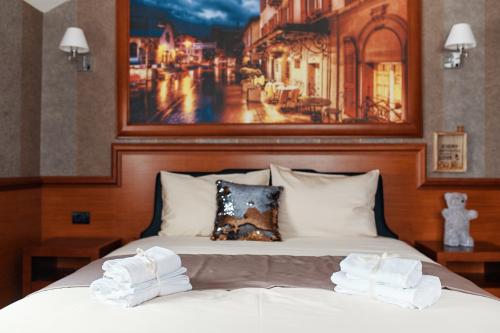 a bedroom with a bed with a picture on the wall at Lux apartmani Beograd in Belgrade