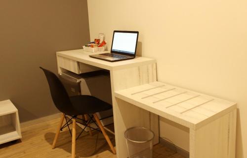 a laptop computer sitting on a white desk with a chair at Awqa Hoteles - Sede Natasha in Trujillo