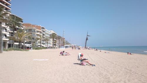 a group of people sitting on a beach at Apt a Calafell plage in Calafell