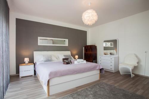 a bedroom with a large bed and a chandelier at Royal View Apartment in Zadar