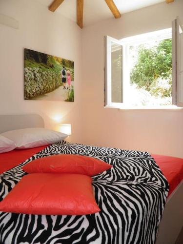 a bedroom with a zebra print bed with a window at Romantic apartment in Koločep