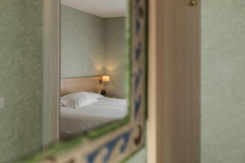 a reflection of a bed in a mirror at Hotel Donatello Imola in Imola