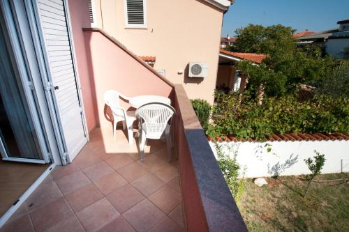 a balcony with a table and chairs on a house at Apartments Maric with parking in Umag
