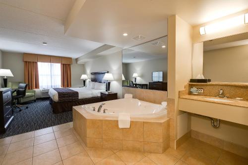 Country Inn & Suites by Radisson, Niagara Falls, ON tesisinde bir odada yatak veya yataklar