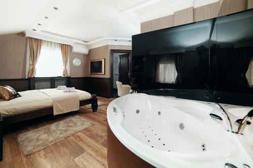 ein großes Bad mit einer Badewanne und einem Bett in der Unterkunft Lux apartmani Beograd in Belgrad
