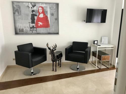 a hair salon with two chairs and a statue of a deer at Gallery Guesthouse in Rome