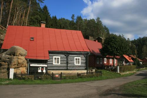 a wooden house with an orange roof on a street at Kräuterbaude in Saupsdorf