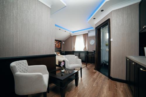 a living room with two chairs and a bed and a table at Lux apartmani Beograd in Belgrade