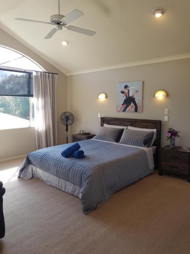 a bedroom with a bed with a blue teddy bear on it at Makepeace Place Homestay in Hamilton