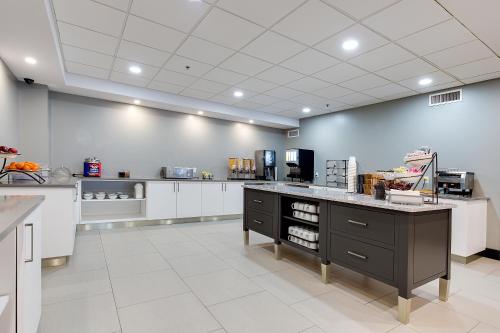 a large kitchen with white cabinets and a counter at Country Inn & Suites by Radisson, Niagara Falls, ON in Niagara Falls