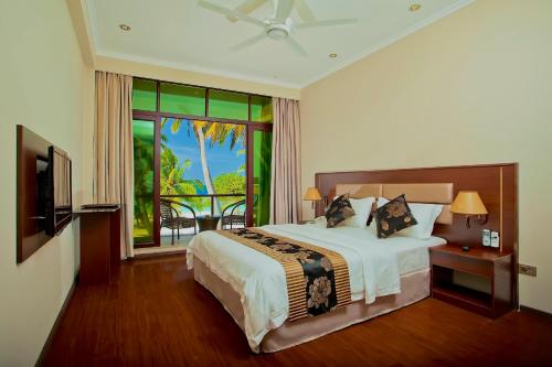 a hotel room with a bed and a balcony at Kaani Beach Hotel in Maafushi
