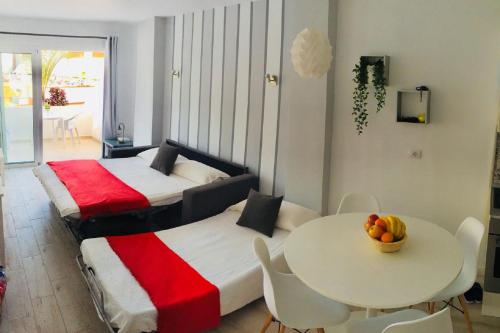 アデへにあるPlaya y sol !!! Parking y wifi gratisのベッド2台、テーブル(フルーツボウル付)が備わる客室です。