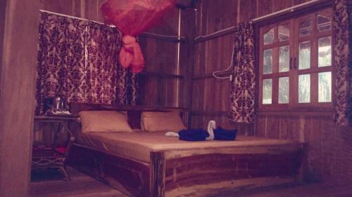 a bedroom with a bed in a room with windows at PSK VIMEAN KOH RONG Guesthouse in Koh Rong Island