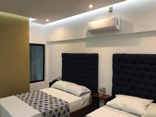 - une chambre avec 2 lits et la climatisation murale dans l'établissement Hotel Plaza Amalia, à Tuxtla Gutiérrez