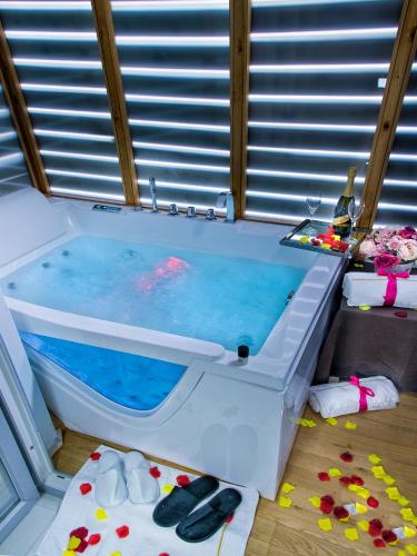 a bath tub filled with blue water in a room at X Hotel in Saviano