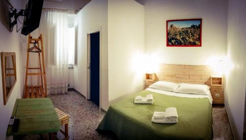 a bedroom with a green bed with towels on it at Casa della Nonna Polignano a mare in Polignano a Mare