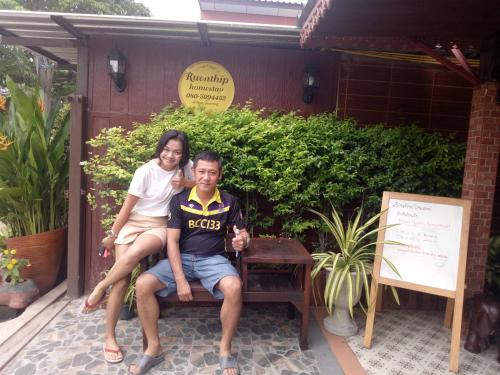 a man and a woman sitting on a bench at Ruenthip Homestay in Bangkok