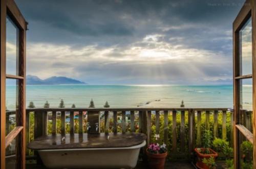a bath tub on a balcony with a view of the ocean at A Room With a View in Kaikoura