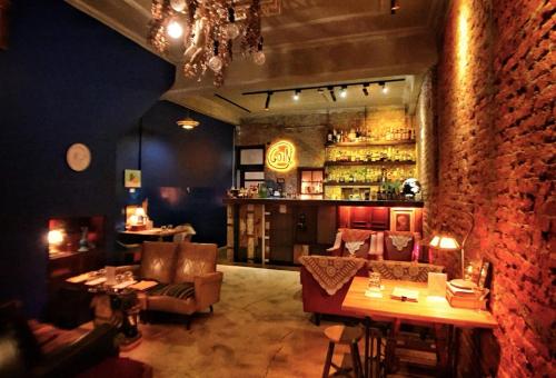 a bar with couches and tables and a brick wall at GOIN Old House & Bar in Tainan