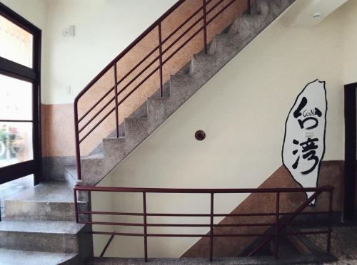 a staircase with a mural of a surfboard on the wall at GOIN Old House & Bar in Tainan