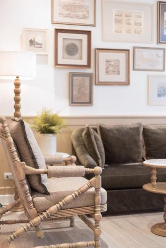 a rattan rocking chair in a living room with a couch at Casa Vimaya Riverside in Bangkok