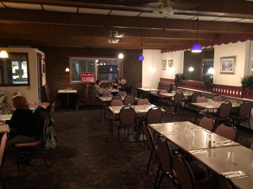 a restaurant with tables and chairs and people sitting at tables at Royal Hotel in Flin Flon