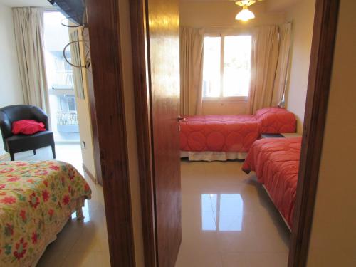 Habitación de hotel con 2 camas y ventana en Departamento Finlay en Villa Carlos Paz