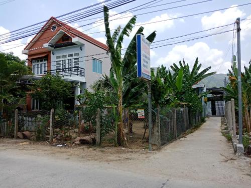 a house with a fence and a sign in front of it at Misa Guesthouse in Dien Khanh