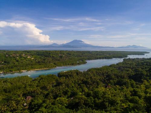 an aerial view of a river with mountains in the background at The Tamarind Resort - Nusa Lembongan in Nusa Lembongan