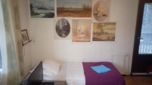 a bedroom with a bed and pictures on the wall at Hotel Lamminpää in Tampere
