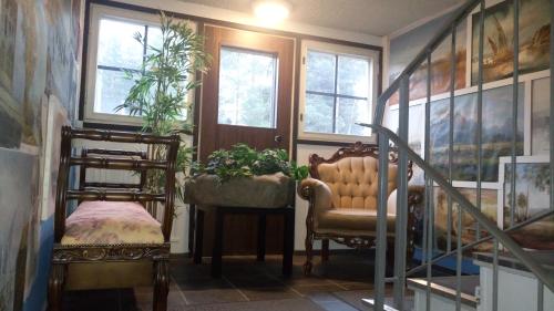 a room with two chairs and a staircase with windows at Hotel Lamminpää in Tampere