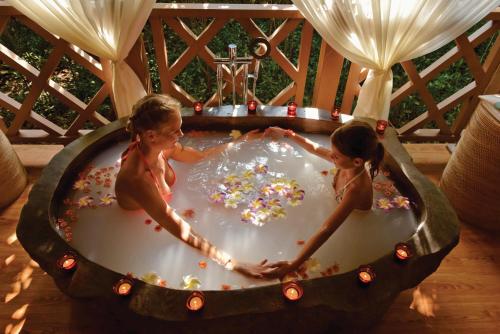 two girls are playing in a bathtub filled with confetti at Dreamland Maldives Resort in Baa Atoll