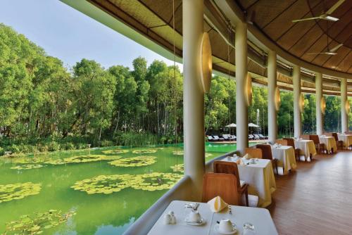 a restaurant with a view of a pond with lilies at Dreamland Maldives Resort in Baa Atoll
